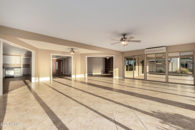 interior space featuring a wall mounted air conditioner, tile patterned floors, a ceiling fan, and baseboards