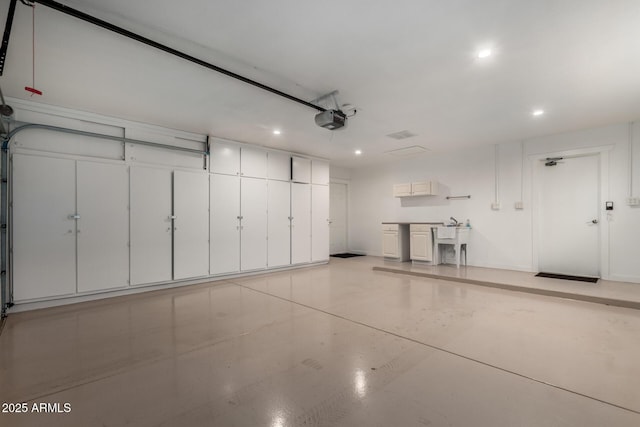 garage with baseboards, recessed lighting, and a garage door opener