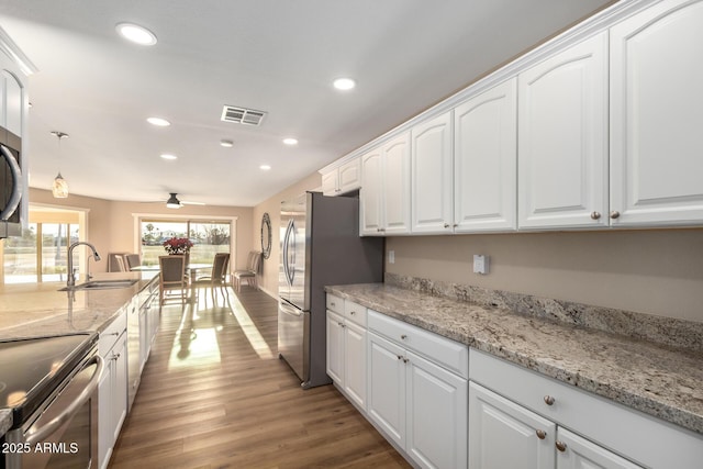 kitchen with dark wood-style flooring, a sink, visible vents, white cabinetry, and appliances with stainless steel finishes