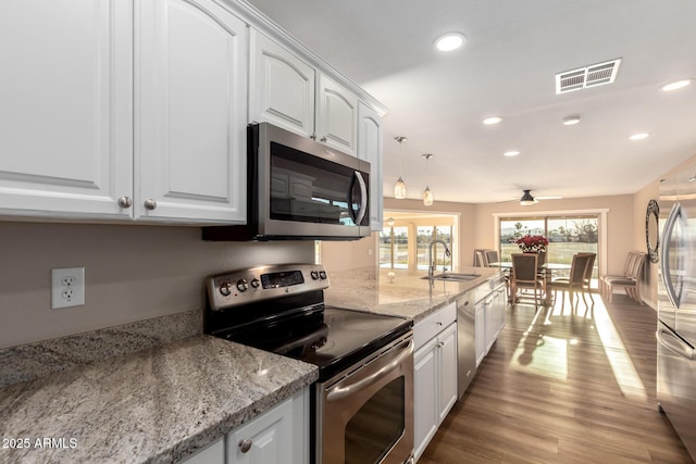 kitchen with visible vents, appliances with stainless steel finishes, white cabinets, and a sink