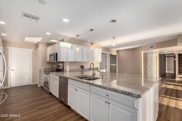 kitchen featuring stainless steel appliances, a sink, visible vents, white cabinetry, and decorative light fixtures