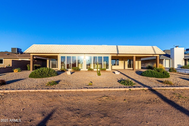 view of front of home featuring central AC, a tiled roof, and stucco siding