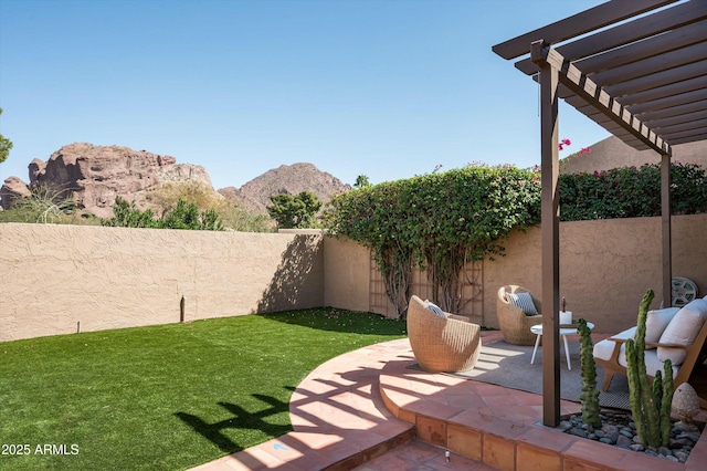 view of yard with a fenced backyard, a mountain view, a pergola, and a patio