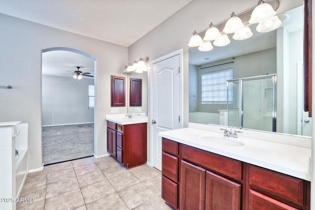 bathroom featuring ceiling fan, a stall shower, a sink, and a bath