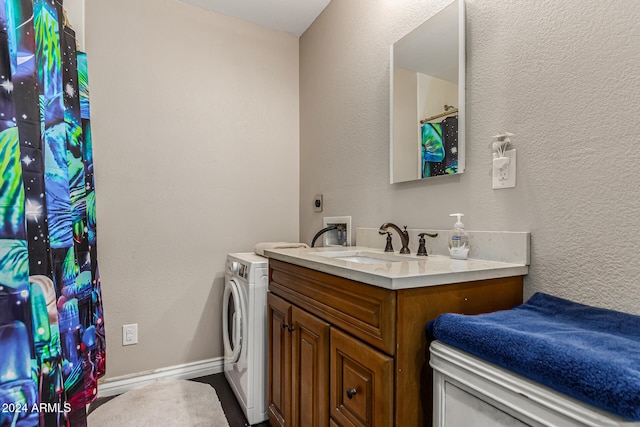 bathroom featuring vanity and washer / dryer