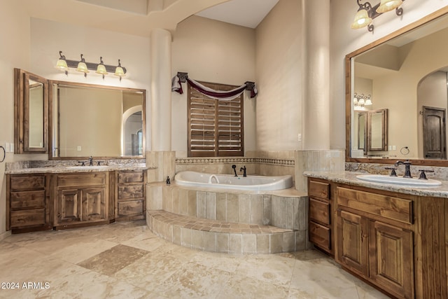 bathroom featuring vanity and a relaxing tiled tub