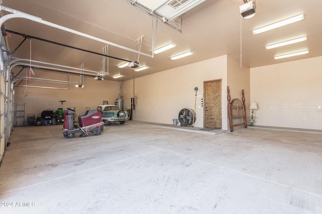 garage with a garage door opener and strapped water heater