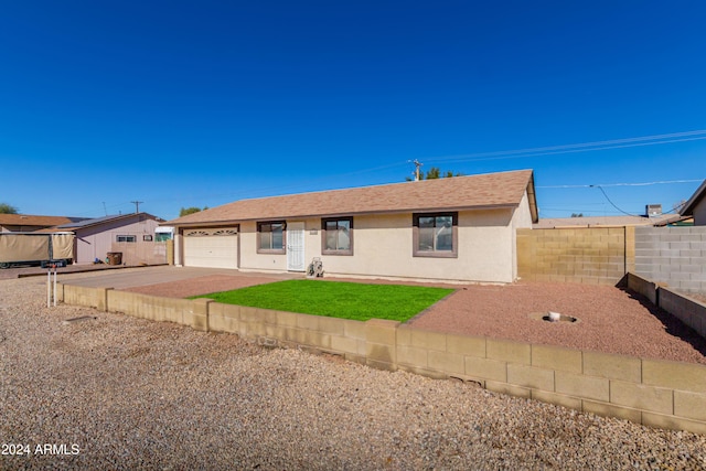 ranch-style house with a garage and a front lawn