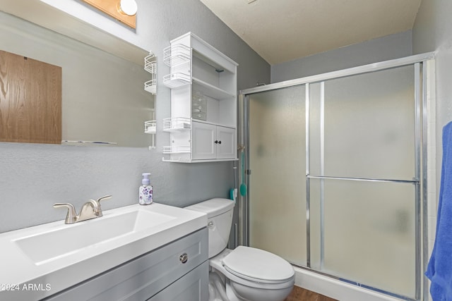 bathroom with wood-type flooring, vanity, toilet, and a shower with door
