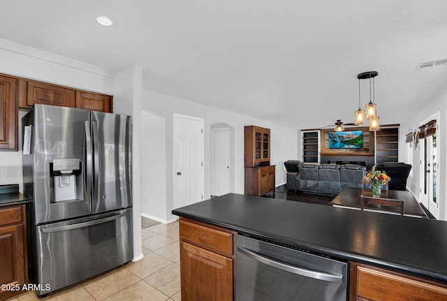 941 E Stirrup Ln, San Tan Valley, AZ 85143 - kitchen with stainless steel appliances, light tile patterned floors, dark countertops, open floor plan, and pendant lighting
