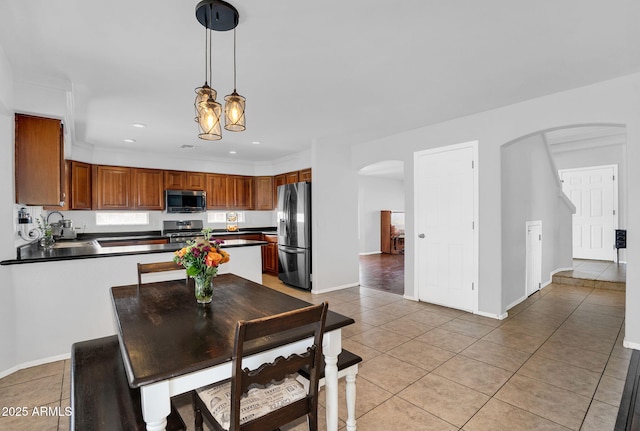 941 E Stirrup Ln, San Tan Valley, AZ 85143 - kitchen featuring appliances with stainless steel finishes, arched walkways, dark countertops, light tile patterned flooring, and recessed lighting