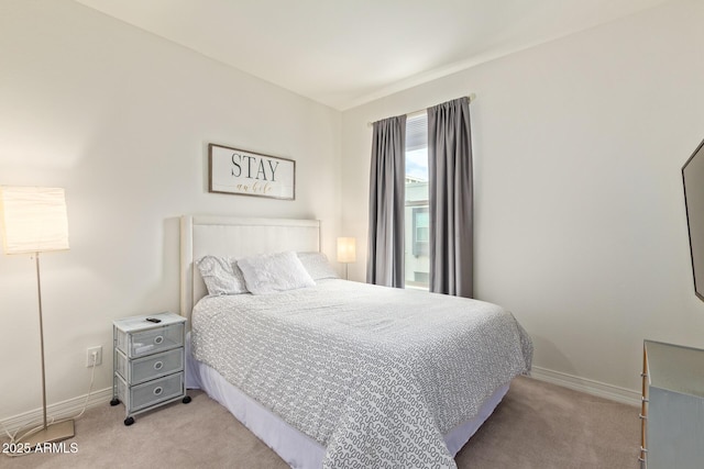 bedroom with light colored carpet and baseboards