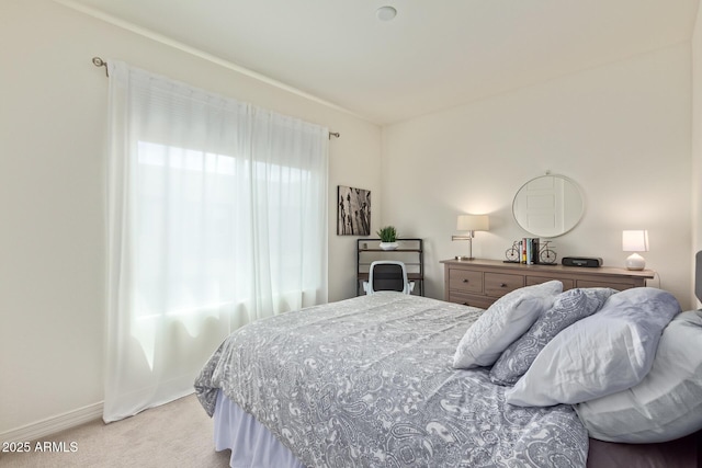 bedroom with baseboards and light colored carpet