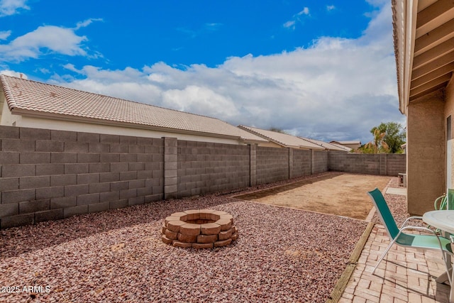 view of yard featuring a fenced backyard, an outdoor fire pit, and a patio