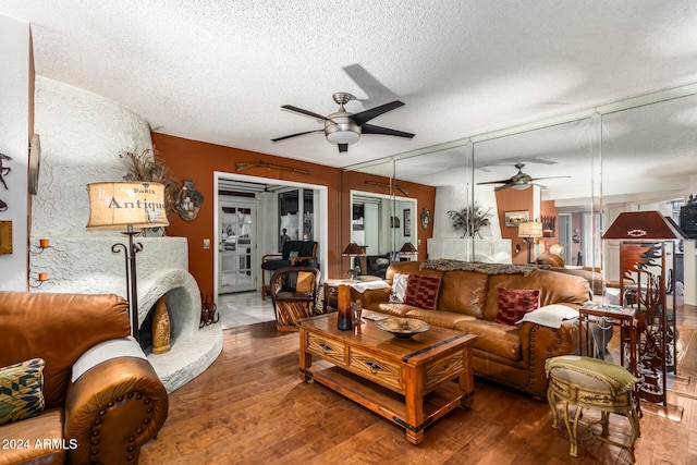 living room featuring hardwood / wood-style floors, a textured ceiling, and ceiling fan