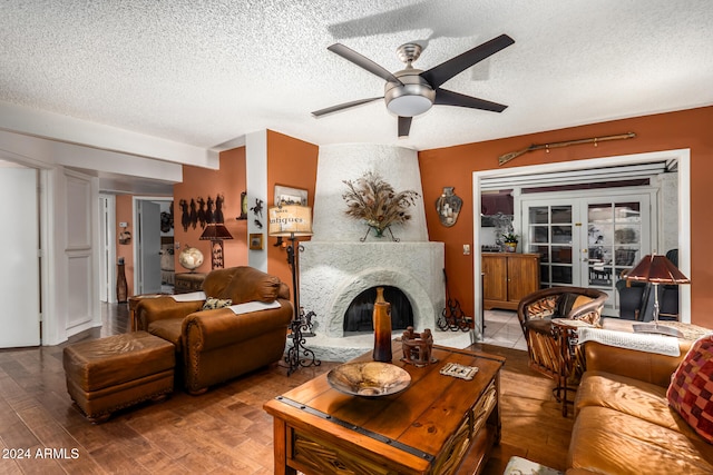 living room featuring french doors, ceiling fan, hardwood / wood-style floors, and a textured ceiling