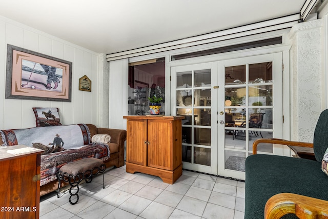 living room featuring light tile patterned floors, french doors, and crown molding