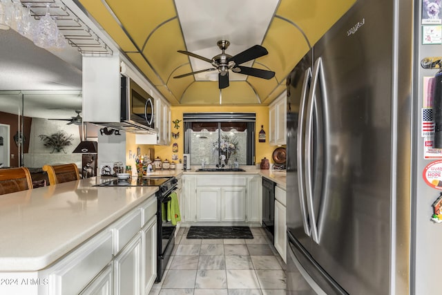 kitchen with lofted ceiling, black appliances, sink, kitchen peninsula, and white cabinetry