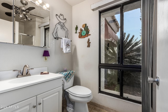 bathroom with tile patterned flooring, vanity, a shower with shower door, and toilet