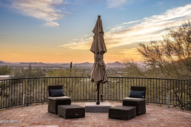 patio terrace at dusk featuring a mountain view