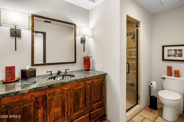 bathroom with tile patterned floors, vanity, toilet, and an enclosed shower