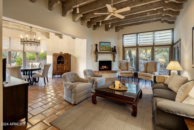 living room featuring a towering ceiling, ceiling fan with notable chandelier, and beamed ceiling