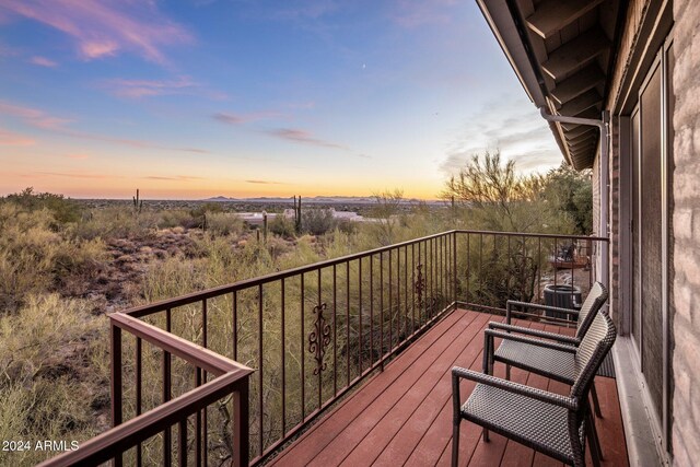 balcony at dusk featuring central AC unit