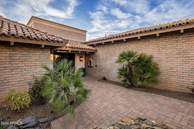 view of exterior entry featuring a patio area