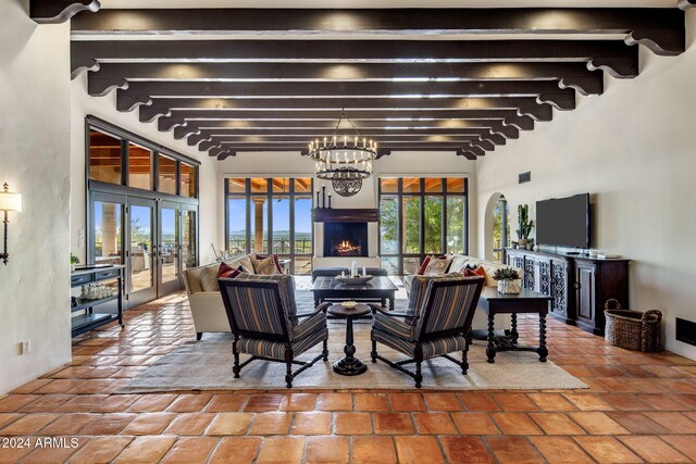 dining space featuring a chandelier, french doors, and beamed ceiling