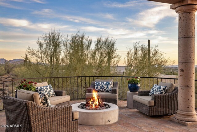 patio terrace at dusk featuring a fire pit