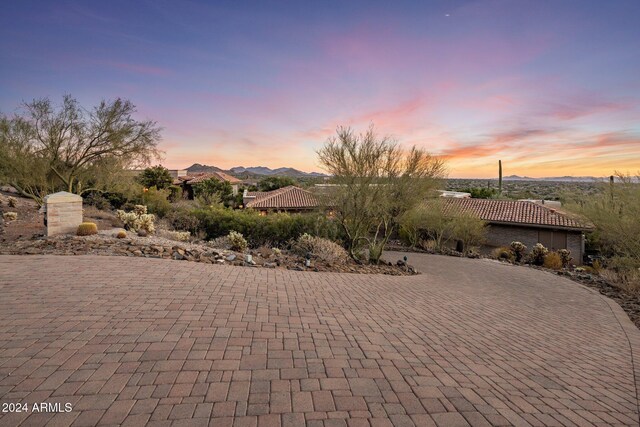 patio terrace at dusk featuring a mountain view