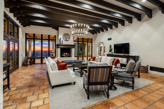 living room featuring beamed ceiling, a notable chandelier, and french doors