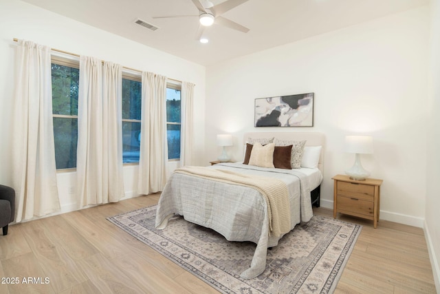 bedroom with baseboards, ceiling fan, visible vents, and light wood-style floors