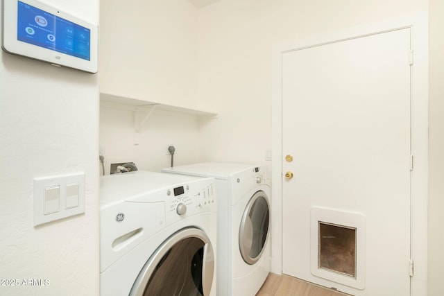 laundry room featuring laundry area, light wood-style flooring, and washing machine and clothes dryer