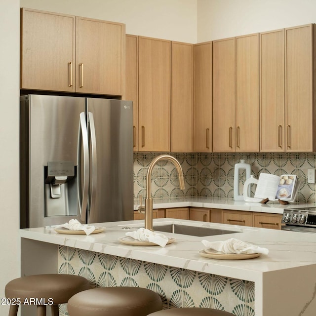 kitchen with a sink, a breakfast bar, stainless steel appliances, and backsplash