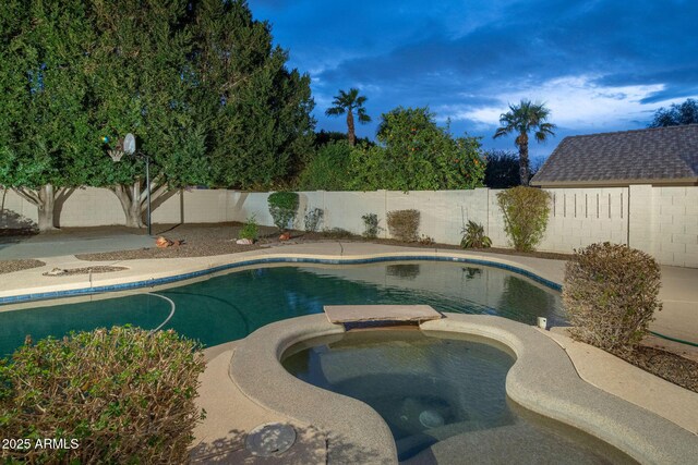 view of swimming pool featuring a fenced backyard and a pool with connected hot tub