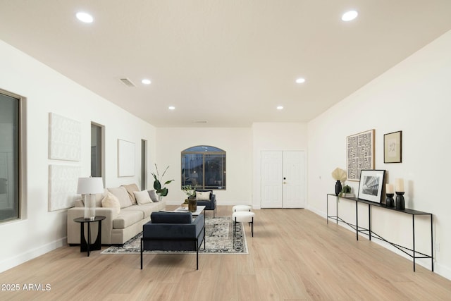 living area with light wood-style floors, recessed lighting, visible vents, and baseboards