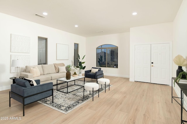 living room featuring light wood-type flooring, visible vents, baseboards, and recessed lighting