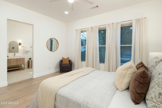 bedroom featuring light wood finished floors, baseboards, visible vents, connected bathroom, and recessed lighting