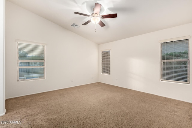 empty room with visible vents, carpet floors, a ceiling fan, and vaulted ceiling