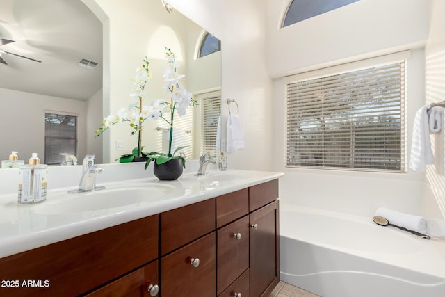 full bath with a sink, visible vents, a garden tub, and double vanity