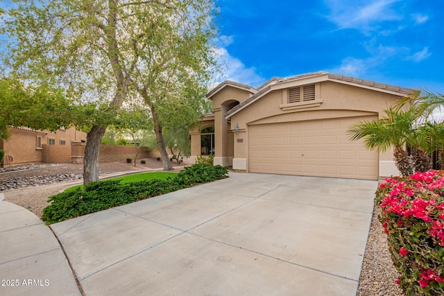 view of front of property with concrete driveway, an attached garage, fence, and stucco siding