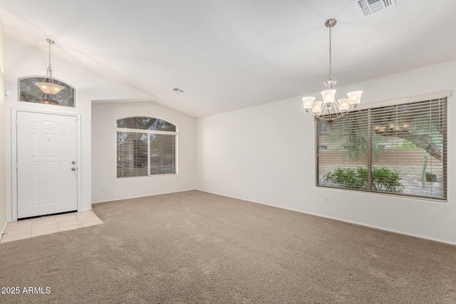 entrance foyer featuring vaulted ceiling, light colored carpet, visible vents, and a chandelier