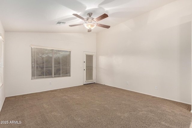 carpeted empty room featuring visible vents, ceiling fan, and vaulted ceiling