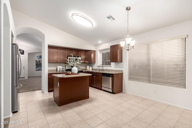 kitchen with visible vents, arched walkways, a sink, vaulted ceiling, and appliances with stainless steel finishes