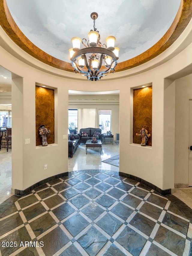 interior space with a tray ceiling and an inviting chandelier