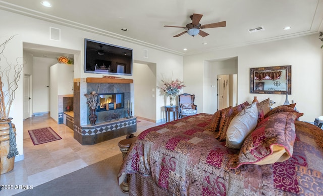 bedroom with ceiling fan, ornamental molding, and a tile fireplace