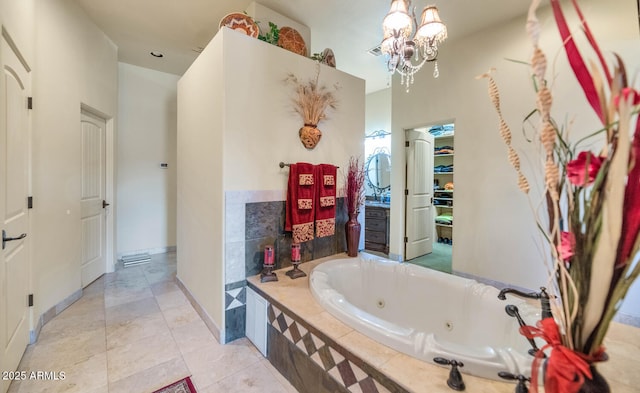 bathroom with tile patterned flooring, an inviting chandelier, and tiled tub