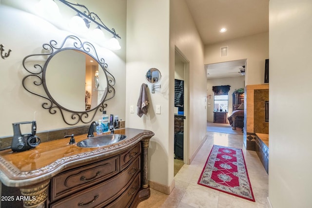 bathroom featuring tile patterned flooring, a tile fireplace, and vanity