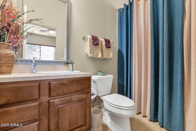 bathroom with toilet, vanity, and tile patterned flooring